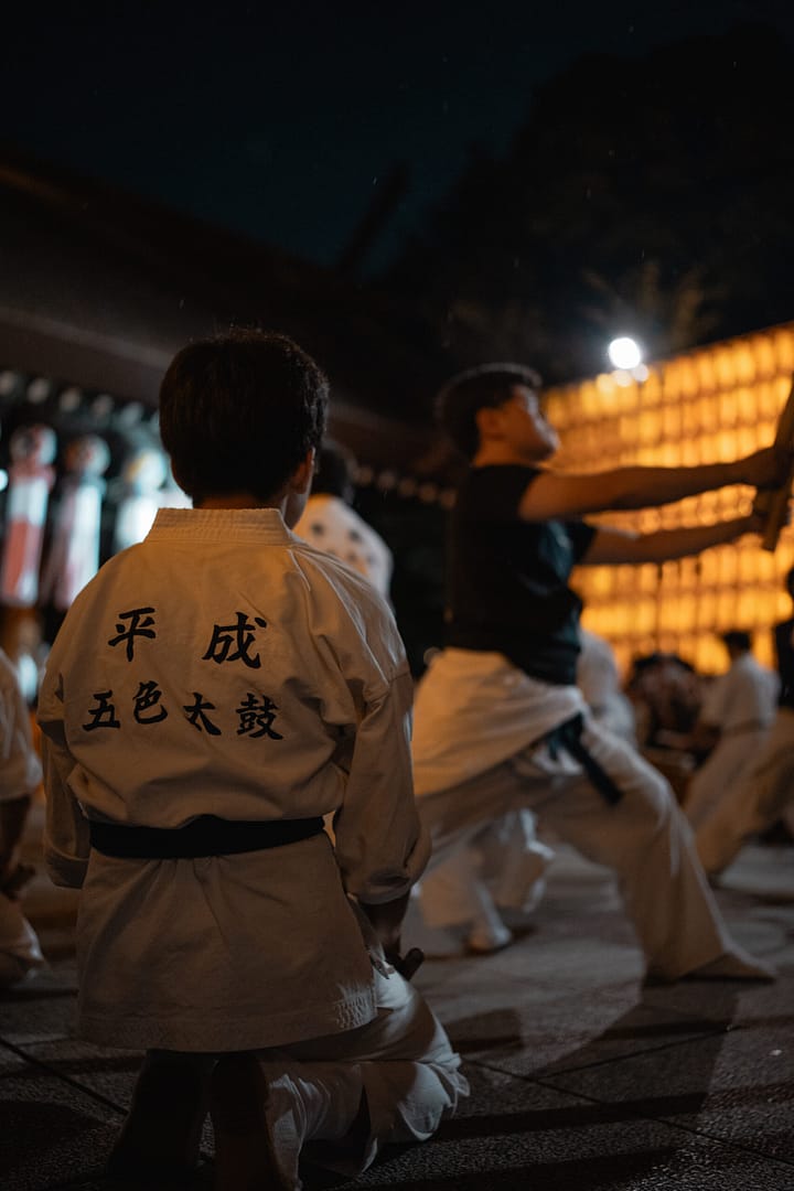 A chield looks at people playing taiko during Mitama festival in Yasukuni Jinja